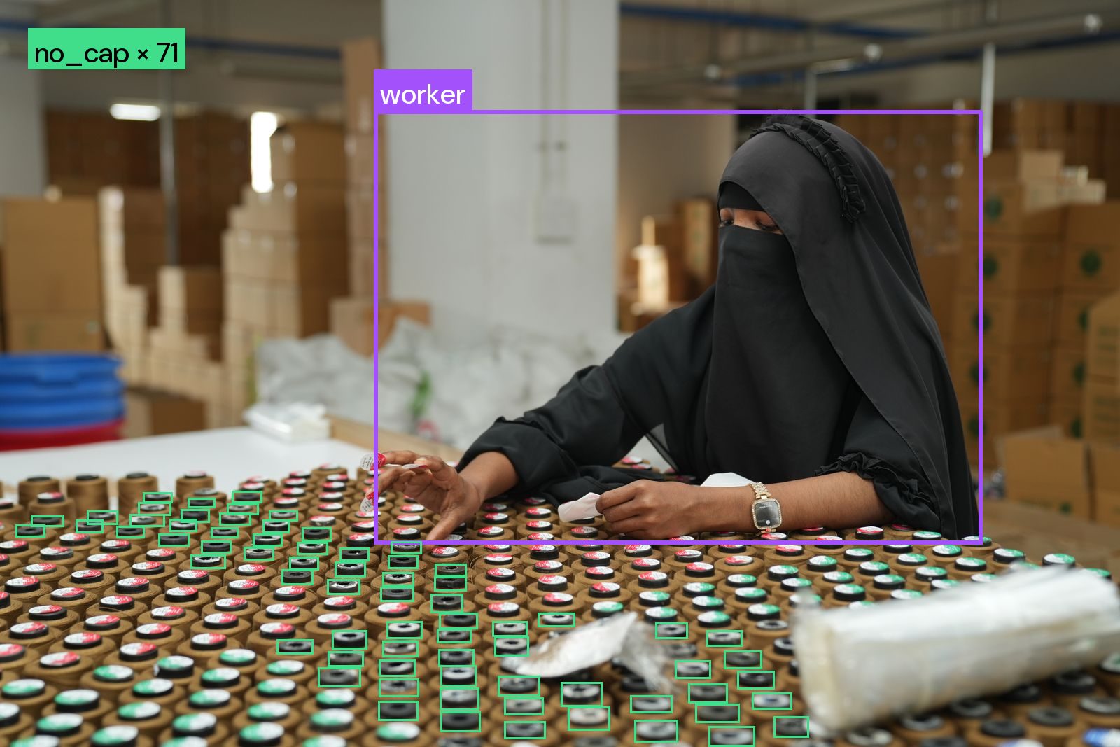 Bottle caps on an inspection table with detection boxes